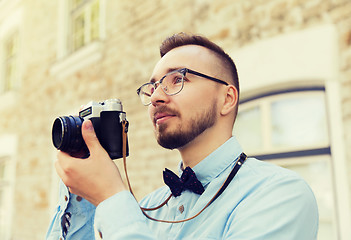 Image showing young hipster man with film camera in city