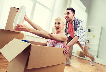 Image showing couple with cardboard boxes having fun at new home