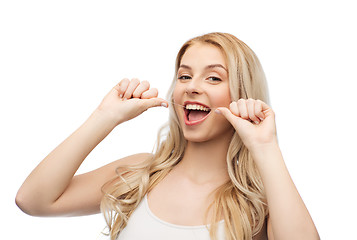 Image showing happy young woman with dental floss cleaning teeth