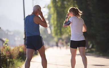 Image showing jogging couple planning running route  and setting music