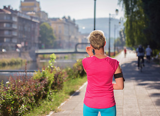 Image showing jogging woman setting phone before jogging