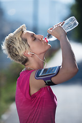 Image showing woman drinking  water after  jogging