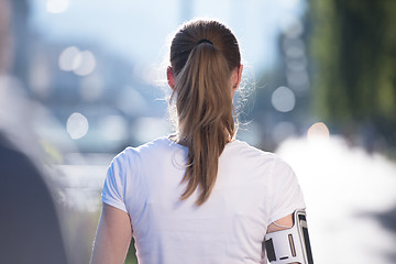 Image showing jogging woman setting phone before jogging