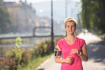 Image showing sporty woman running  on sidewalk