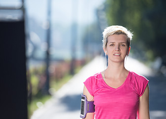 Image showing jogging woman setting phone before jogging