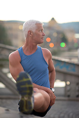 Image showing handsome man stretching before jogging