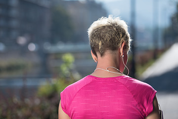 Image showing jogging woman setting phone before jogging
