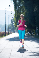 Image showing sporty woman running  on sidewalk