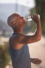 Image showing senior jogging man drinking fresh water from bottle