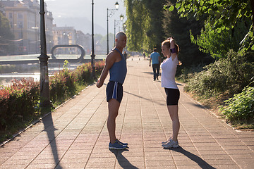 Image showing couple warming up and stretching before jogging