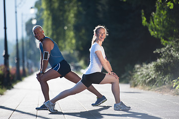 Image showing couple warming up and stretching before jogging