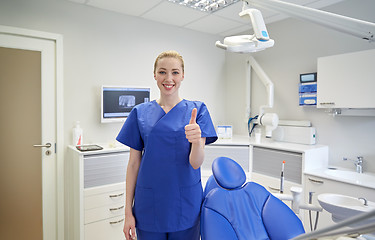 Image showing happy female dentist showing thumbs up at clinic