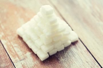 Image showing close up of white sugar pyramid on wooden table