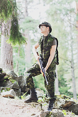 Image showing young soldier or hunter with gun in forest