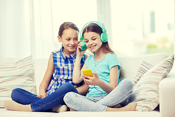 Image showing happy girls with smartphone and headphones