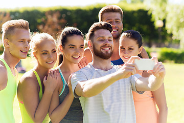 Image showing happy friends taking selfie with smartphone