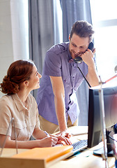 Image showing happy creative team calling on phone in office