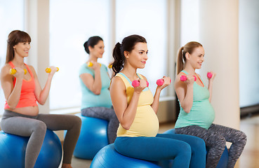 Image showing happy pregnant women exercising on fitball in gym