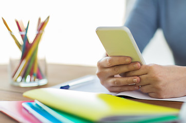 Image showing close up of student with smartphone and notebook