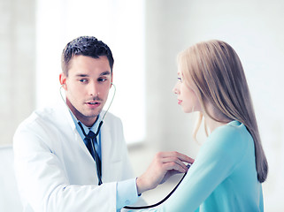 Image showing doctor with stethoscope listening to the patient