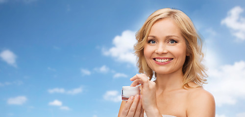 Image showing happy woman with cream jar