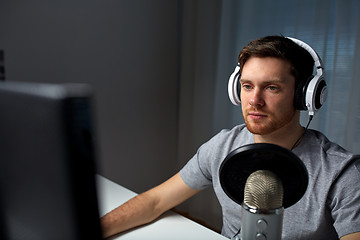 Image showing man in headset playing computer video game at home