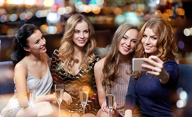 Image showing women with champagne taking selfie at night club