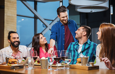 Image showing friends dining and drinking wine at restaurant