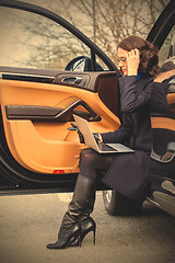 Image showing woman sitting on the threshold of the car