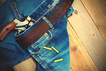 Image showing fashion old blue jeans and vintage revolver