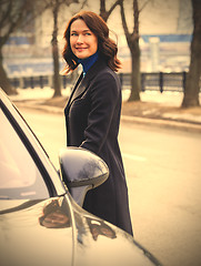 Image showing woman in a dark coat near car