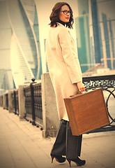Image showing woman in a bright coat and a wooden case