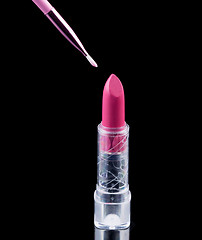 Image showing Tube of lipstick with a brush make-up on black 