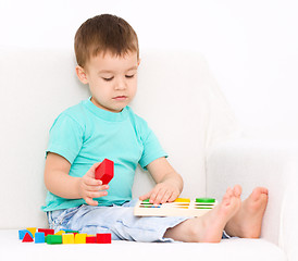 Image showing Boy is playing with puzzle