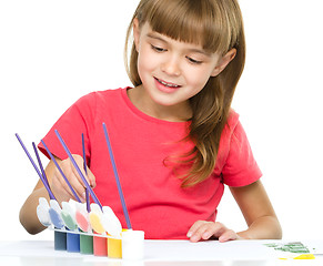 Image showing Little girl is painting with gouache