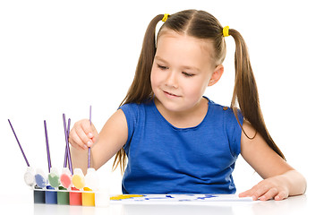 Image showing Little girl is painting with gouache