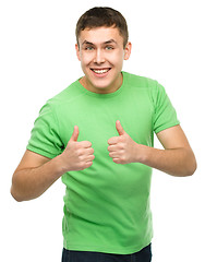 Image showing Cheerful young man showing thumb up sign