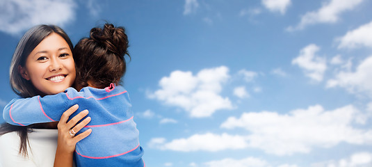 Image showing hugging mother and daughter over sky background