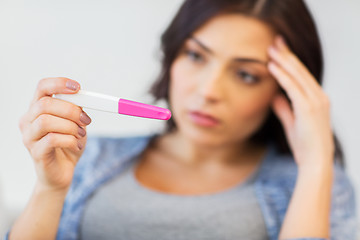 Image showing close up of sad woman with home pregnancy test