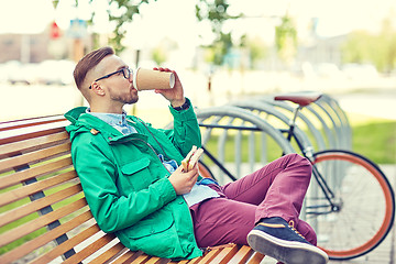 Image showing happy young hipster man with coffee and sandwich