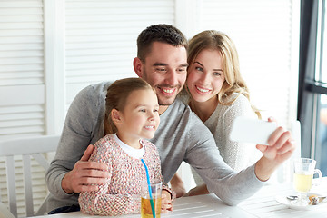 Image showing happy family taking selfie at restaurant