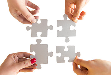 Image showing close up of hands connecting puzzle pieces