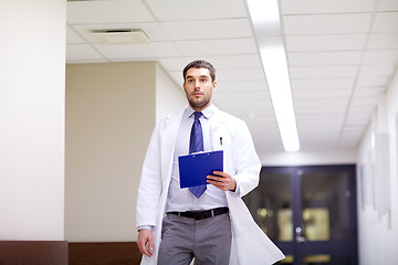 Image showing doctor with clipboard walking along hospital