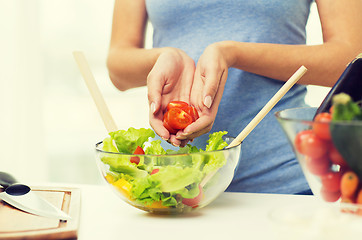 Image showing close up of woman cooking vegetable salad at home