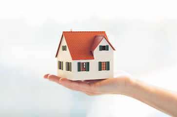 Image showing close up of hands holding house or home model