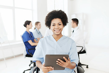 Image showing happy nurse with tablet pc over team at hospital