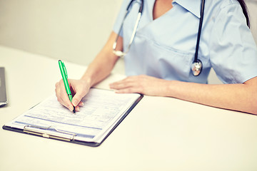 Image showing close up of female doctor writing prescription