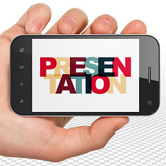 Image showing Advertising concept: Hand Holding Smartphone with Presentation on  display