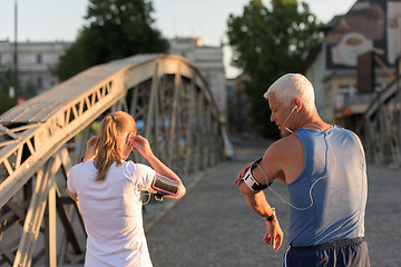 Image showing jogging couple planning running route  and setting music