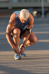 Image showing Man tying running shoes laces